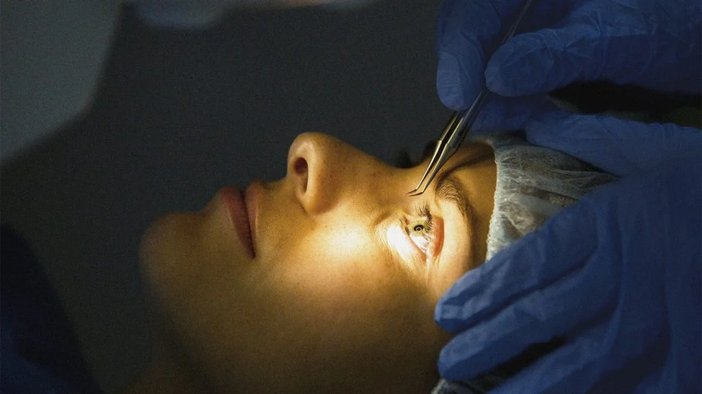 a woman getting eyelash extensions done